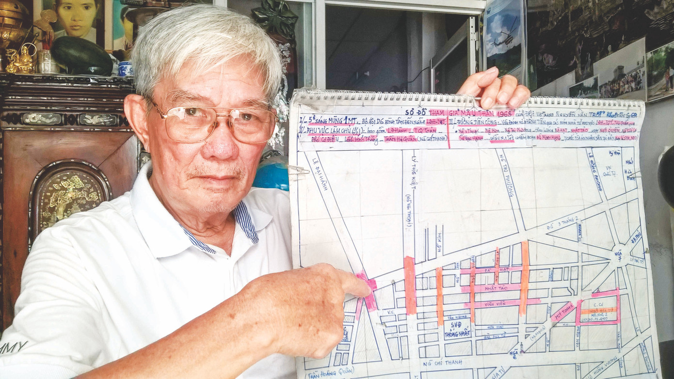 Anh Năm Trọng và tấm bản đồ ghi lại các trận chiến đấu của lực lượng võ trang Thành Đoàn cùng bộ đội trong đợt 1 chiến dịch Mậu Thân. Ảnh: Trần Nguyễn Anh