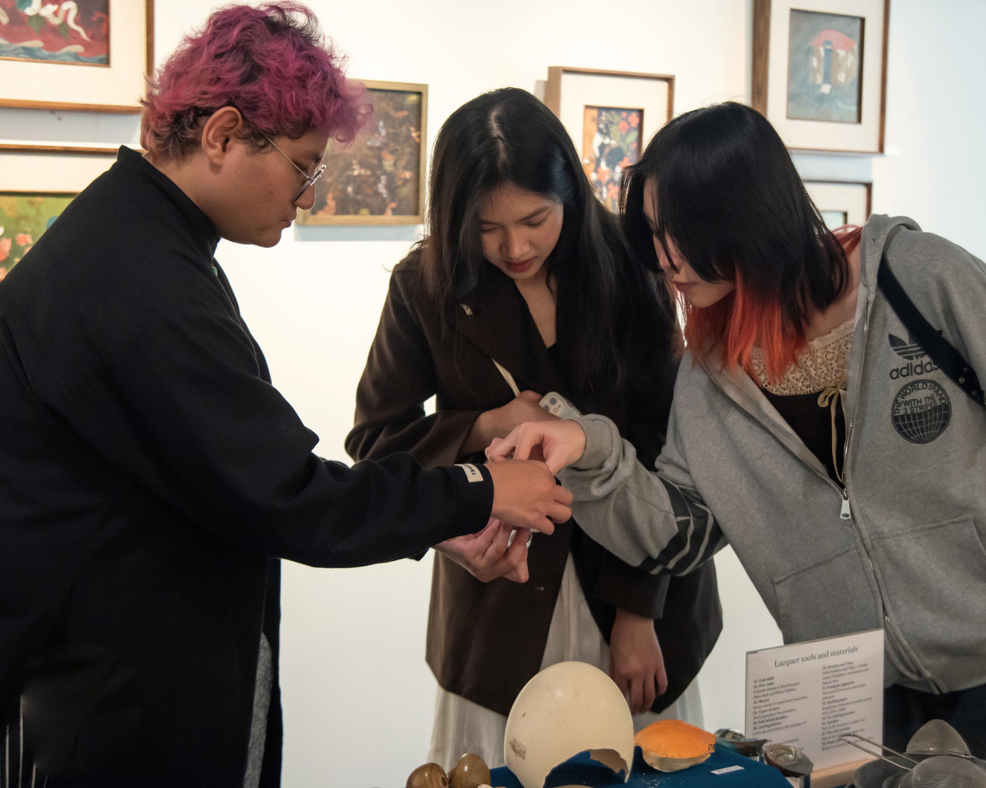 Họa sĩ Phạm Khắc Thắng đang giới thiệu cho người xem các nguyên liệu của tranh sơn mài.