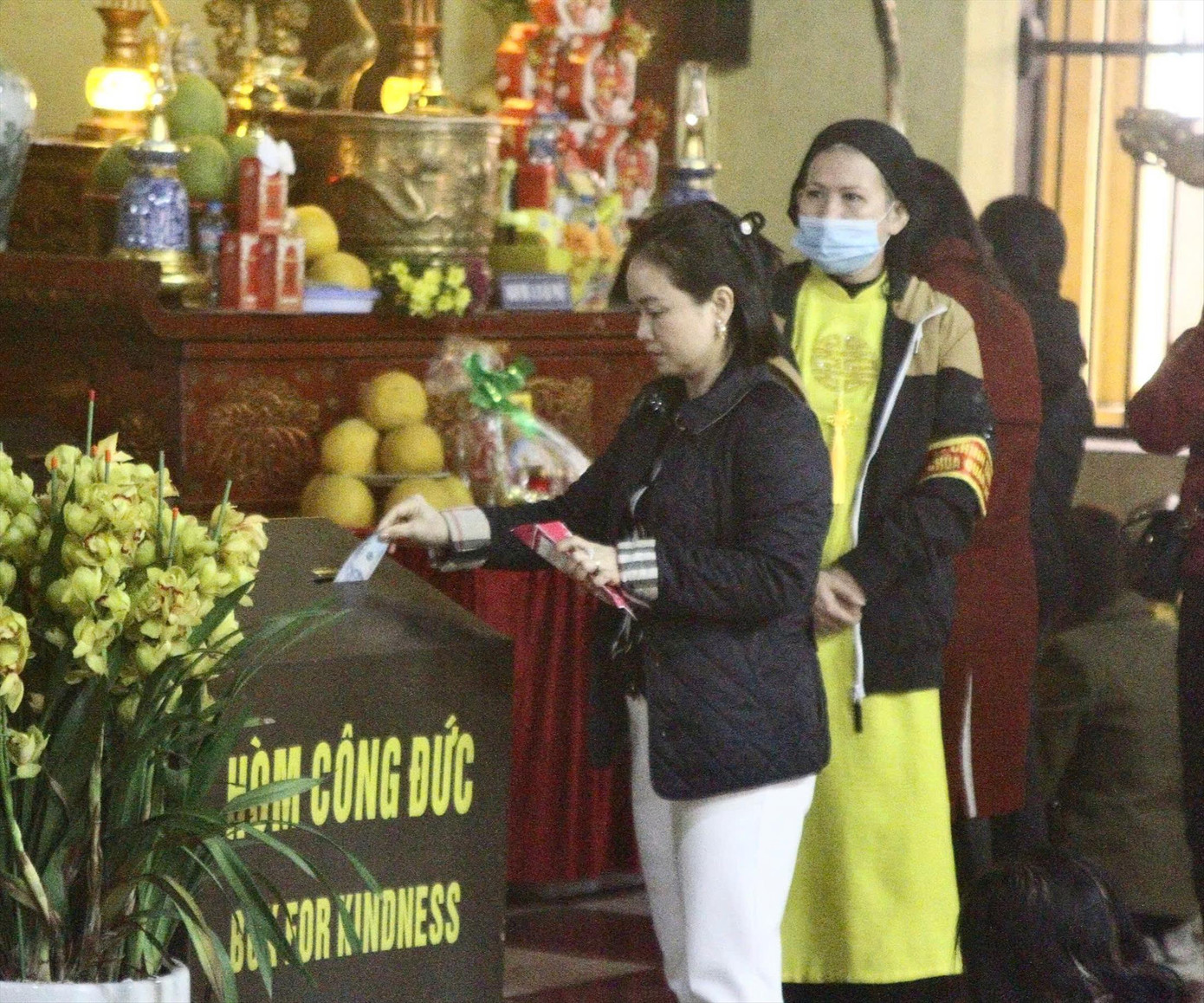 Người dân bỏ tiền công đức vào hòm khi đi lễ tại chùa Quán Sứ (quận Hoàn Kiếm, TP Hà Nội)