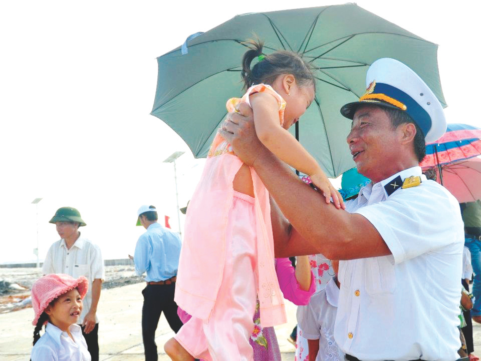 Thượng tá Ngô Duy Đỗ (Phó tham mưu trưởng Lữ đoàn 146) bế cháu Hồ Song Tất Minh ngay khi đến đảo Song Tử Tây. Ảnh: CÔNG HOAN