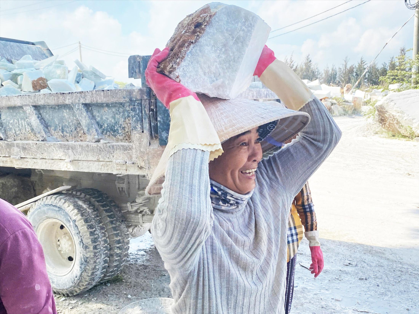 Ngoài công việc tạc tượng, những phụ nữ ở đây còn tham gia vận chuyển đá vụn kiếm thêm thu nhập. Ảnh: Minh Hiền