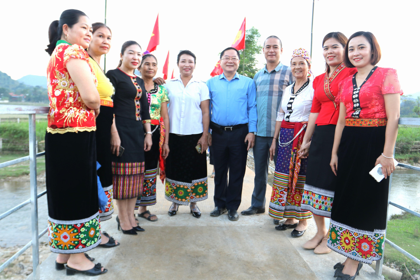 Nhà báo Lê Xuân Sơn - Tổng Biên tập báo Tiền Phong (thứ 5, phải sang) và nhà báo Trần Quang Long - Trưởng Ðại diện báo Tiền Phong tại Nghệ An chụp hình lưu niệm cùng các cô giáo tại lễ khánh thành cây cầu bản Tổng Chai