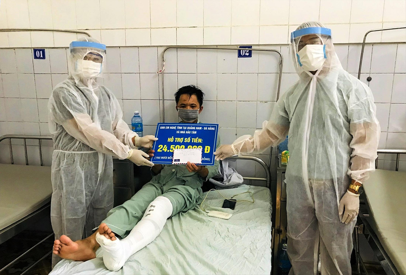 Anh Nguyễn Đình Phượng nhận tiền giúp đỡ từ người xa lạ tại Bệnh viện đa khoa miền núi phía bắc Quảng Nam. Ảnh: V.A