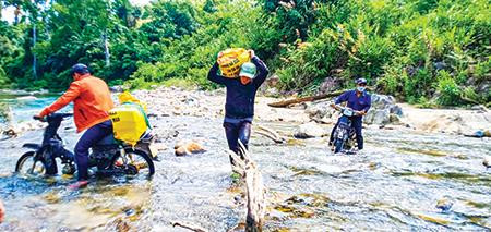 Đoàn viên thanh niên Huyện Đoàn Nam Giang băng rừng, lội suối vận chuyển vật liệu xây “Mái ấm biên cương”. Ảnh: Nguyễn Thành