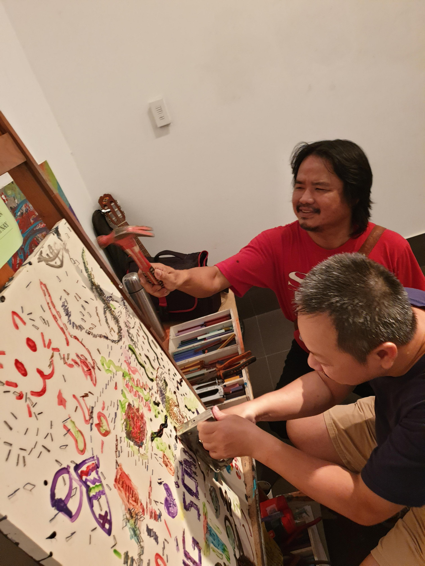 Họa sĩ Nguyễn Sơn (áo đỏ) hướng dẫn khán giả làm tranh ghim