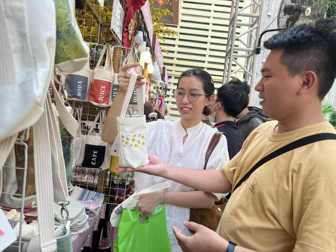 Thanh Hùng (bìa phải) bán túi vải tại hội chợ Tết, nói rằng ngày 30 tháng Chạp sẽ về đón Tết đoàn viên cùng gia đình. Ảnh: U.P Thanh Hùng (bìa phải) bán túi vải tại hội chợ Tết, nói rằng ngày 30 tháng Chạp sẽ về đón Tết đoàn viên cùng gia đình. Ảnh: U.P