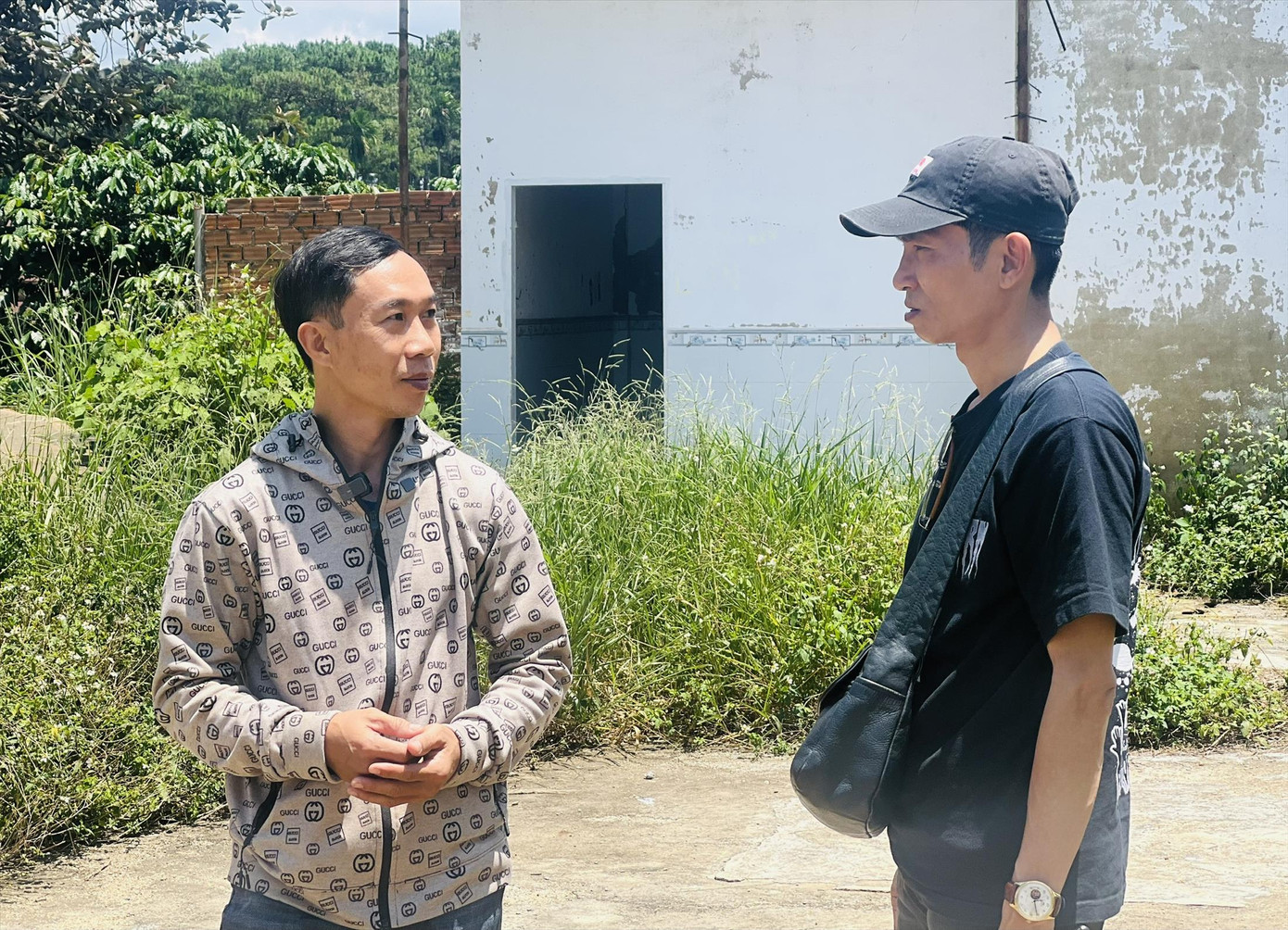 Anh Dũng (bên trái) trước ngôi nhà đã bị dỡ bỏ