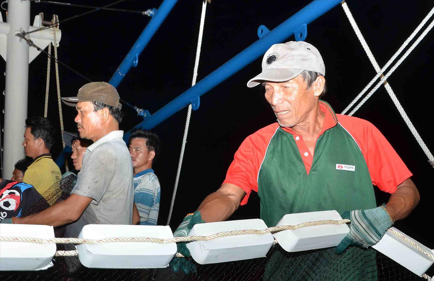 Lão ngư dân Nguyễn Ðông (bìa phải) ở cửa biển Kỳ Hà, tỉnh Quảng Nam là thế hệ ngư dân thường quan sát trời, mây, nước để đoán định thời tiết. Ảnh: Văn Chương