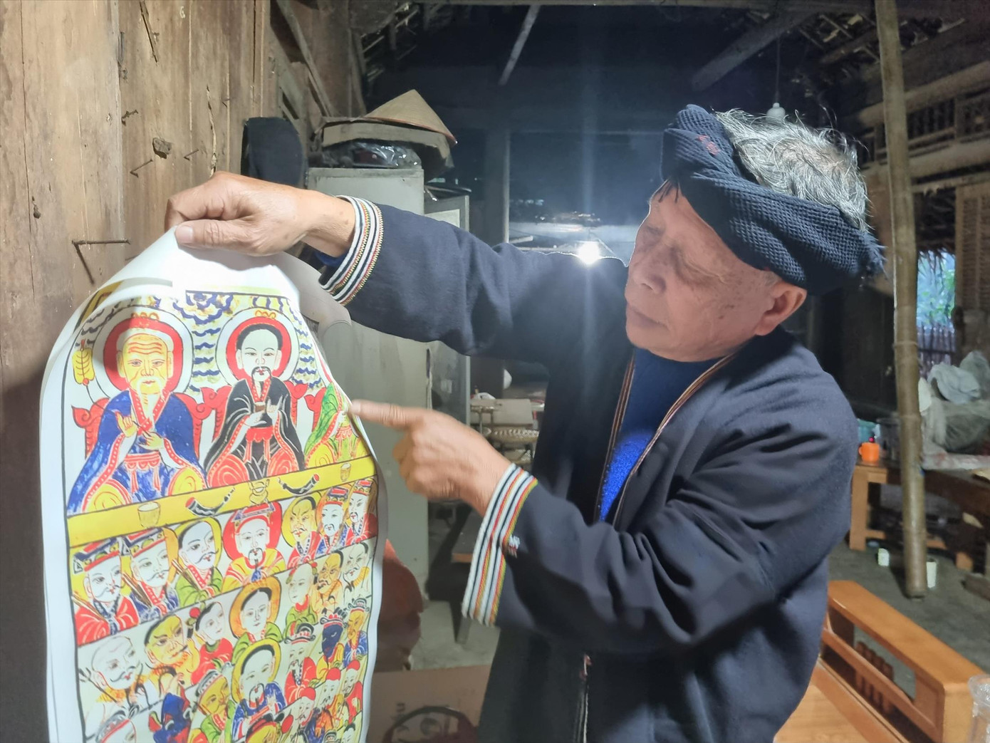 Nghệ nhân ưu tú Lý Văn Hềnh bên bức tranh về tập tục văn hóa thờ cúng của người Dao Tiền. Nghệ nhân ưu tú Lý Văn Hềnh bên bức tranh về tập tục văn hóa thờ cúng của người Dao Tiền.