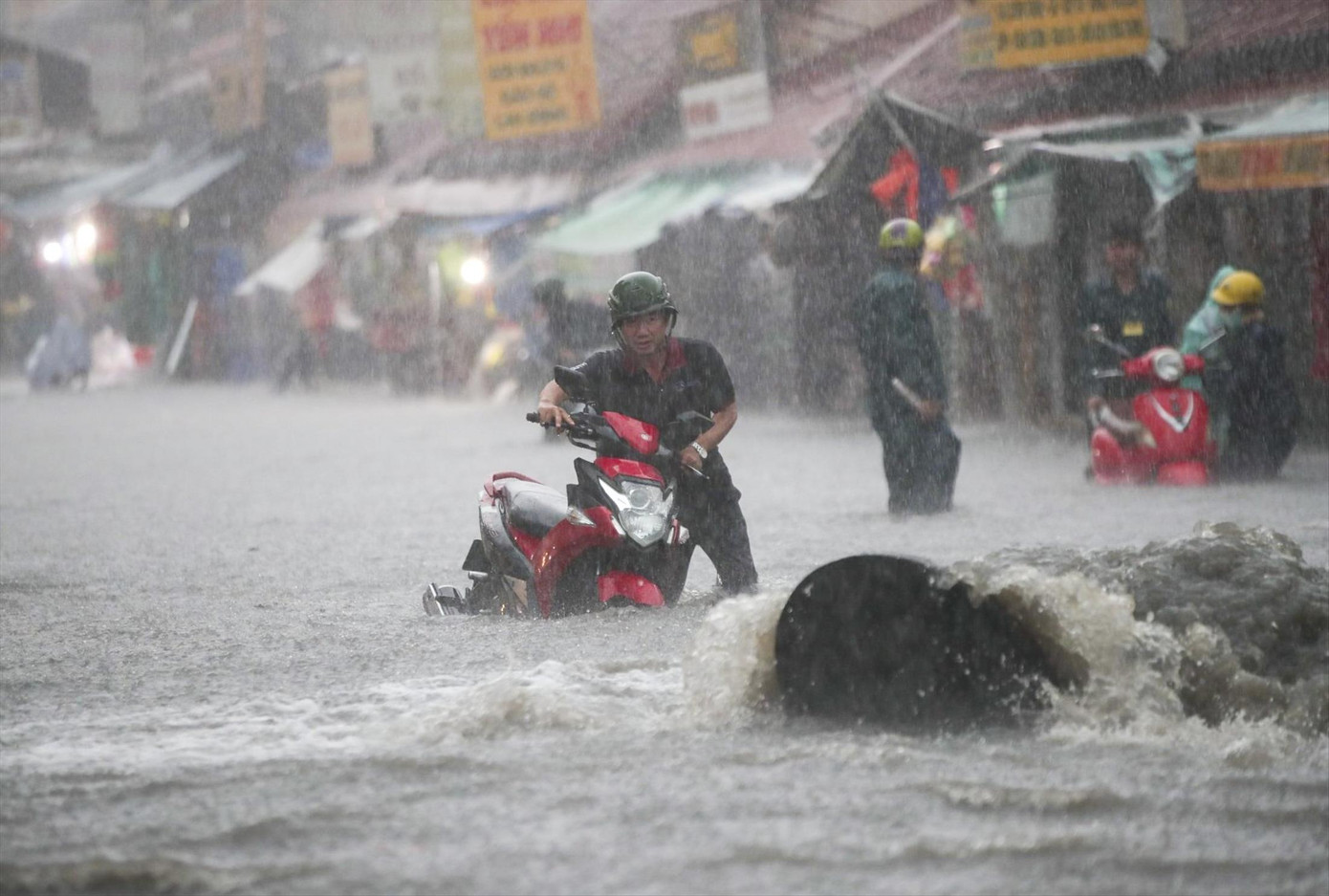 Nước tràn từ miệng cống gây ngập nặng khu vực chợ Thủ Đức. Ảnh: Duy Anh