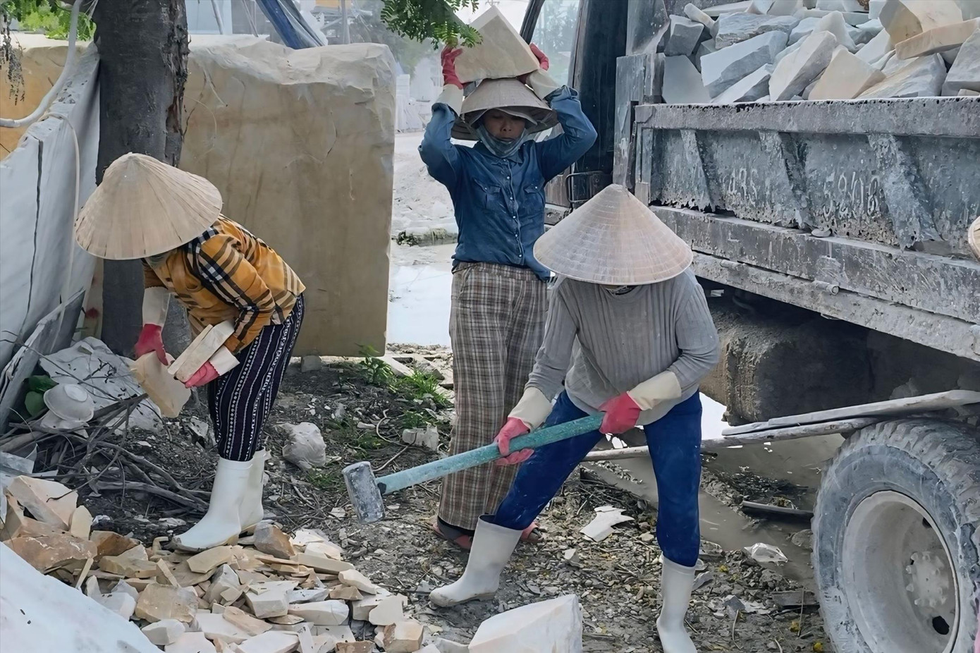 Ngoài công việc tạc tượng, những phụ nữ ở đây còn tham gia vận chuyển đá vụn kiếm thêm thu nhập. Ảnh: Minh Hiền