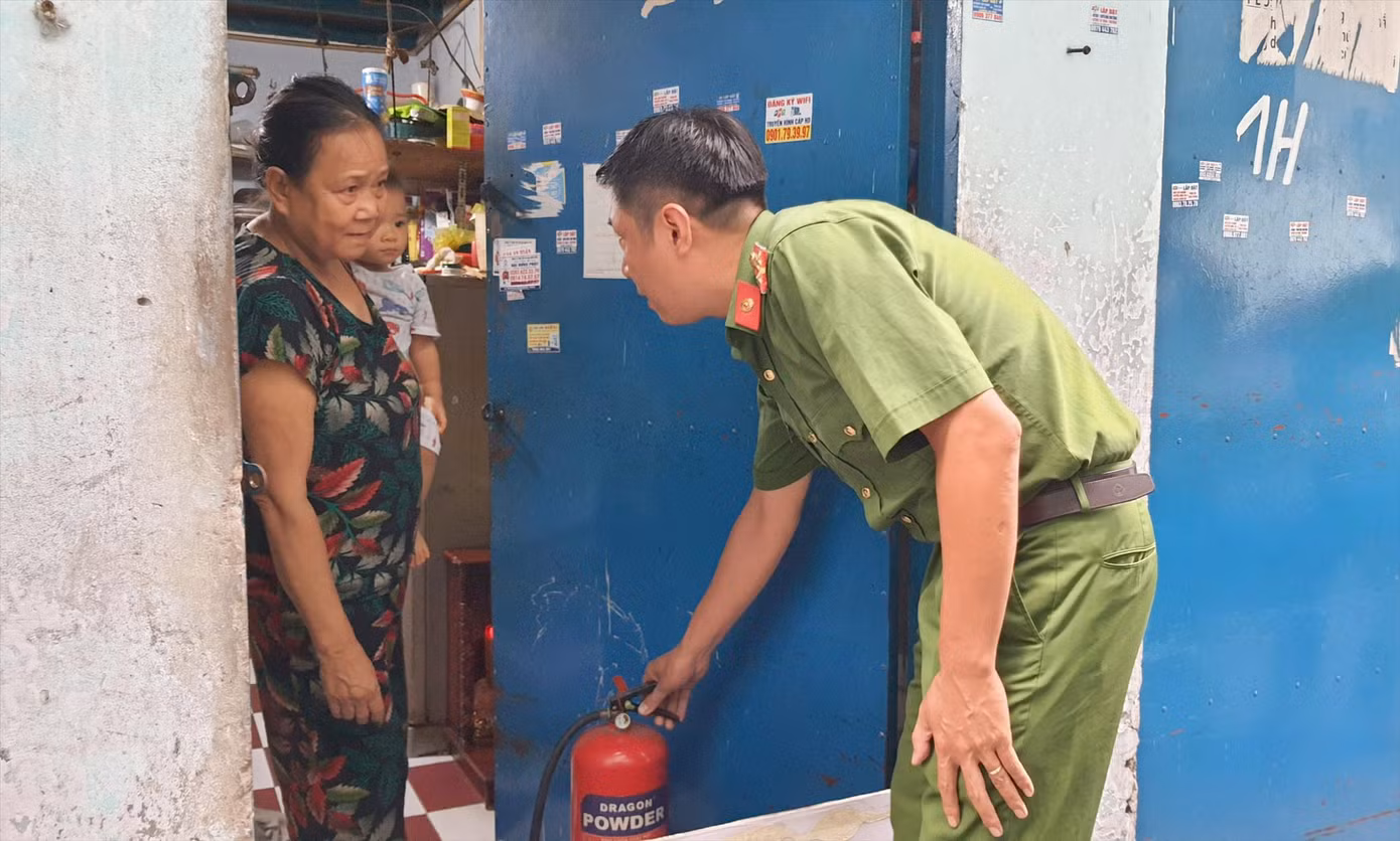 Công an TPHCM hướng dẫn người dân sử dụng bình chữa cháy tại phòng trọ ở quận Tân Phú. Ảnh: Hoàng Thuận