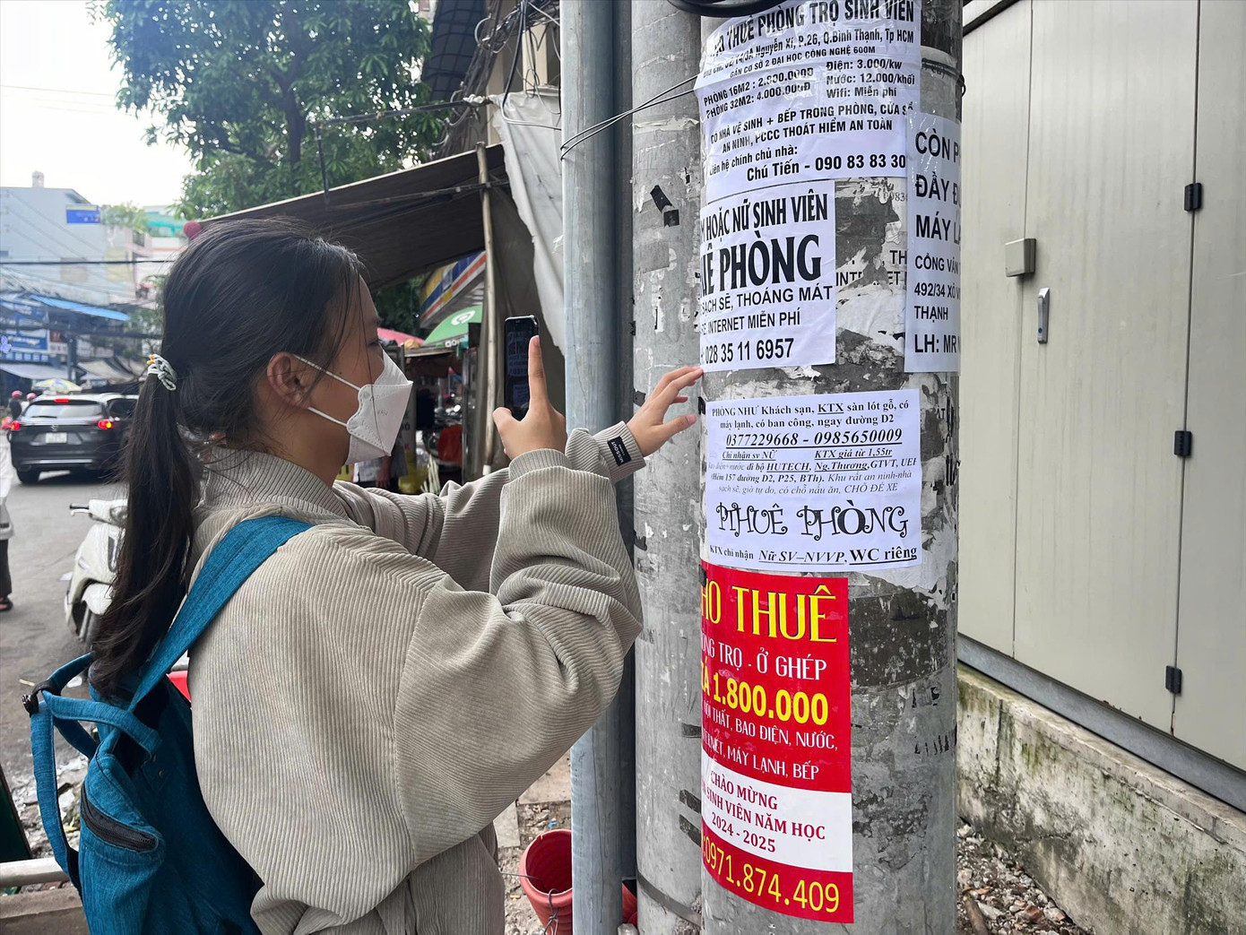 Sinh viên tìm thông tin phòng trọ trên tờ rơi dán trước cổng Trường ĐH Giao thông vận tải TPHCM. Ảnh: Nhàn Lê