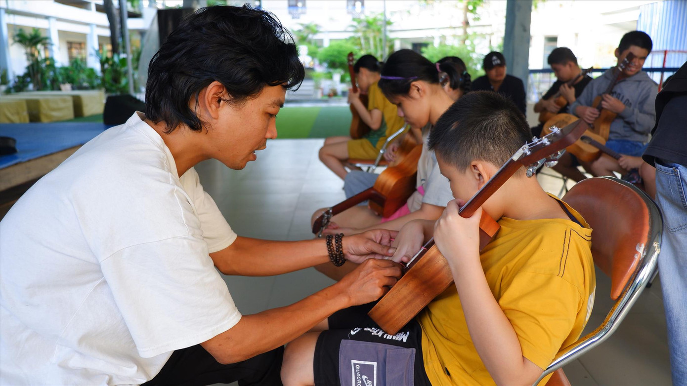 Anh Trương Lương Hy (bìa trái) bên lớp dạy đàn miễn phí cho trẻ em khiếm thị Anh Trương Lương Hy (bìa trái) bên lớp dạy đàn miễn phí cho trẻ em khiếm thị