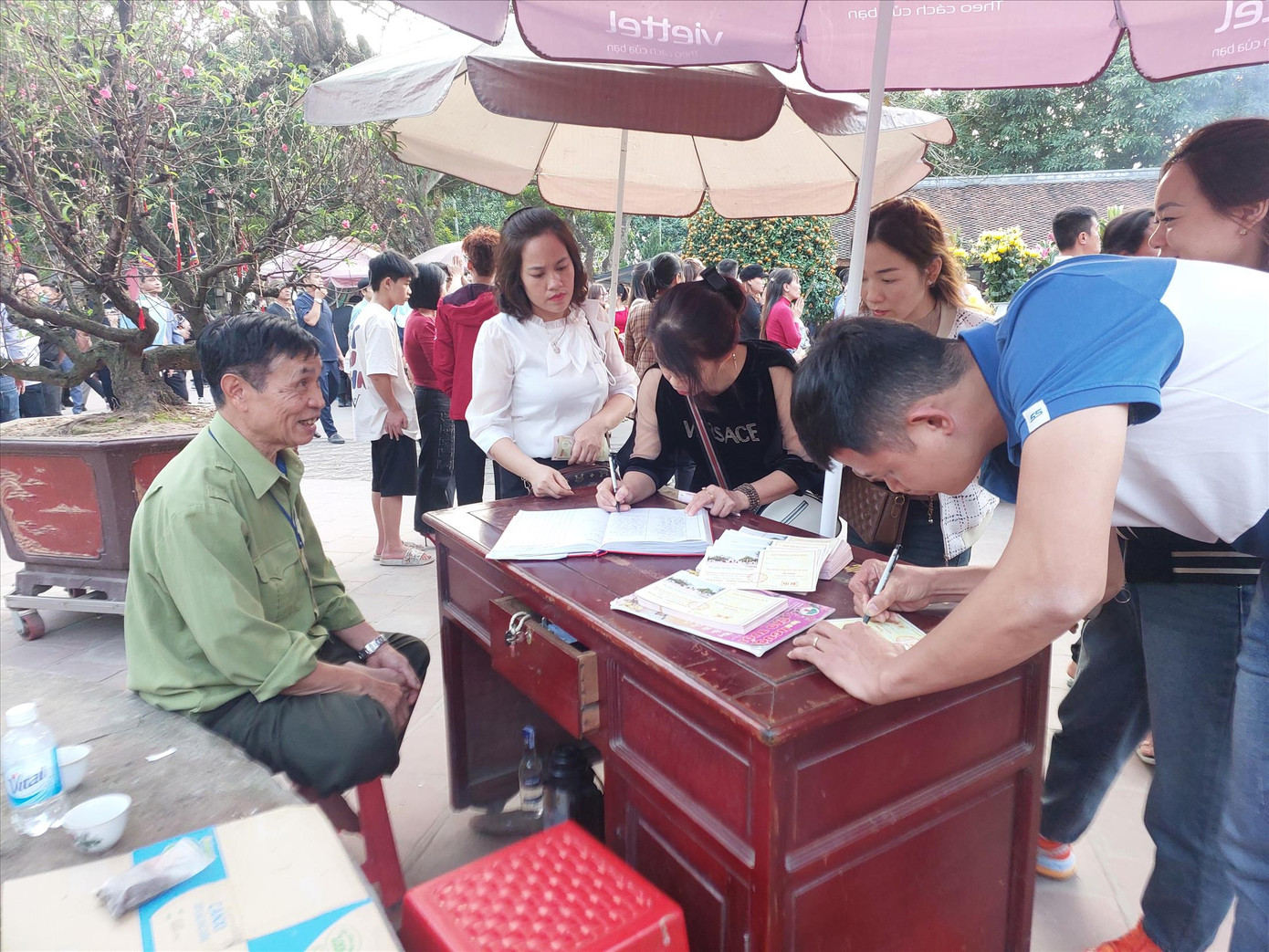 Người dân ghi phiếu ủng hộ tiền công đức tại Đền Trần (Nam Định). Ảnh: Q.N