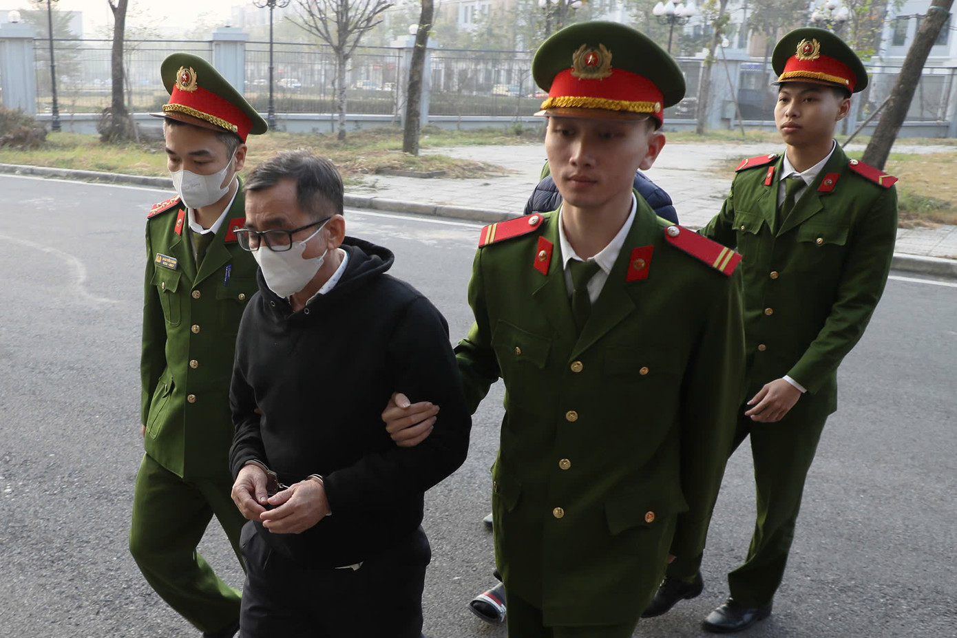 Cảnh sát dẫn giải bị cáo vào phòng xét xử. Cảnh sát dẫn giải bị cáo vào phòng xét xử.