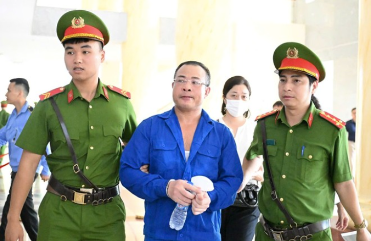 Bị cáo Nghiêm Quang Minh được dẫn giải tới tòa.