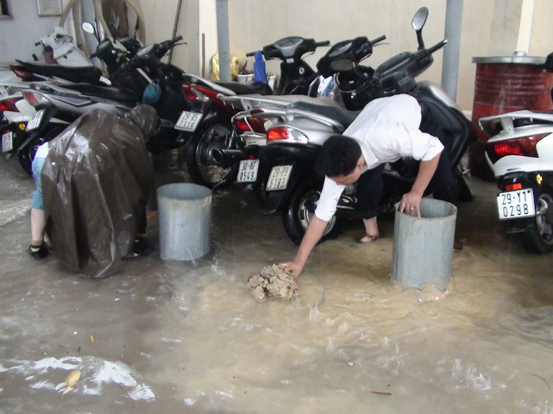 Đất bùn được huy động để giải cứu hầm chứa xăng. Ảnh chụp tại cây xăng trên đường Trần Quang Khải