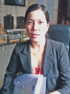 Cô Trần Hồng Ly với hồ sơ kiện quyết định buộc thôi việc. ẢNH: SÁU NGHỆ