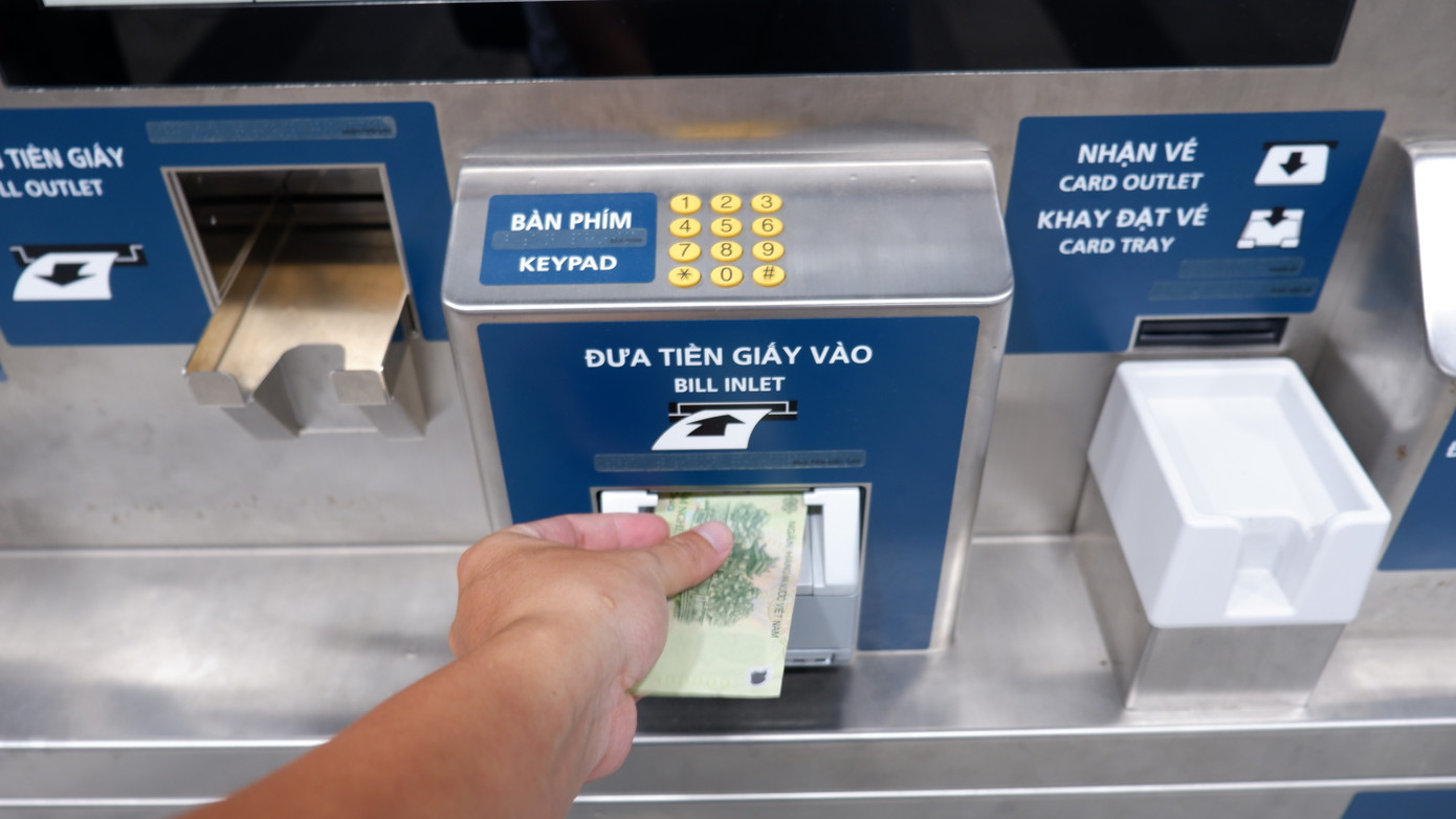 Sau đó, đưa tiền vào nơi quy định.