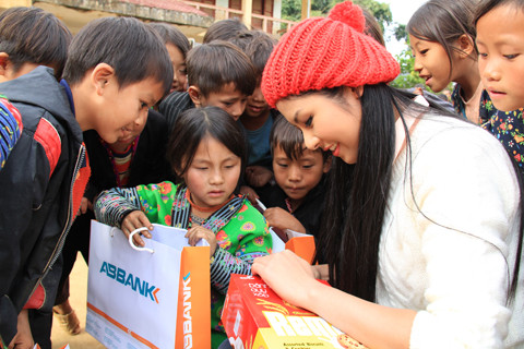 Ngọc Hân chia bánh cho các em học sinh. Ảnh: Trường Phong. Ảnh 8: Hoa hậu Ngọc Hân lấy bánh chia cho các em học sinh. Ảnh: Trường Phong