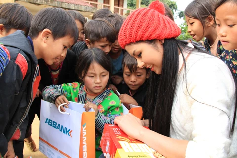 Ảnh 8: Hoa hậu Ngọc Hân lấy bánh chia cho các em học sinh. Ảnh: Trường Phong