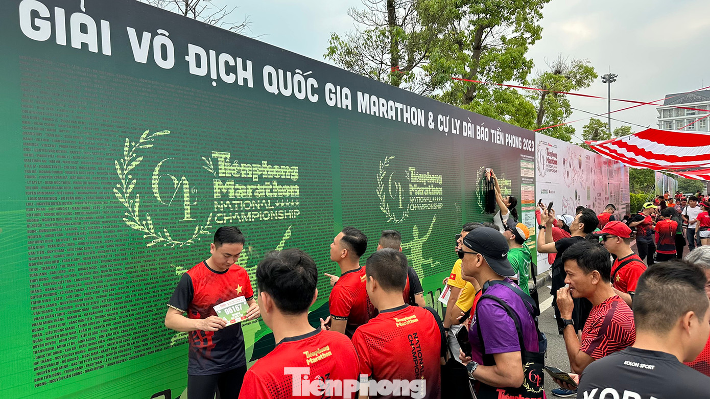 Các vận động viên tìm kiếm tên của mình tại bảng ghi danh các cự ly chạy Tiền Phong Marathon 2023.