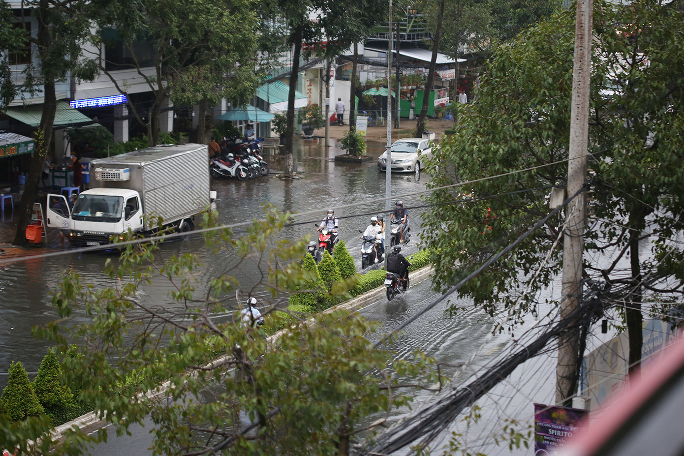 Đường Trần Văn Hoài có một số đoạn triều cường dâng cao ở cả hai bên đường, khiến các phương tiện giao thông đi lại khó khăn. Ảnh: Trường Phong.