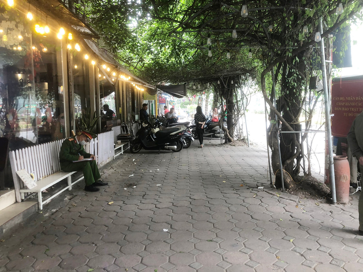 Lực lượng chức năng lập biên bản, xử lý quán cà phê vi phạm vỉa hè ở Khu đô thị Linh Đàm. Ảnh: Công an phường Hoàng Liệt cung cấp.