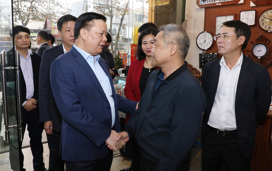 Bí thư Thành uỷ Hà Nội Đinh Tiến Dũng trao đổi với người dân trên địa bàn quận Hà Đông - nơi dự án đường Vành đai 4 - Vùng Thủ đô đi qua. Ảnh: PV.