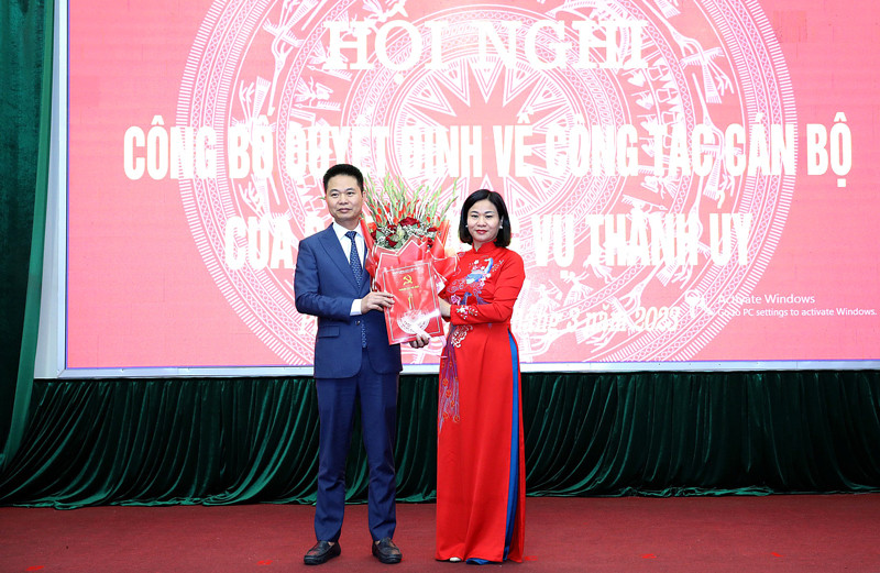 Phó Bí thư Thường trực Thành uỷ Hà Nội Nguyễn Thị Tuyến trao quyết định và tặng hoa chúc mừng ông Nguyễn Xuân Thanh. Ảnh: PV