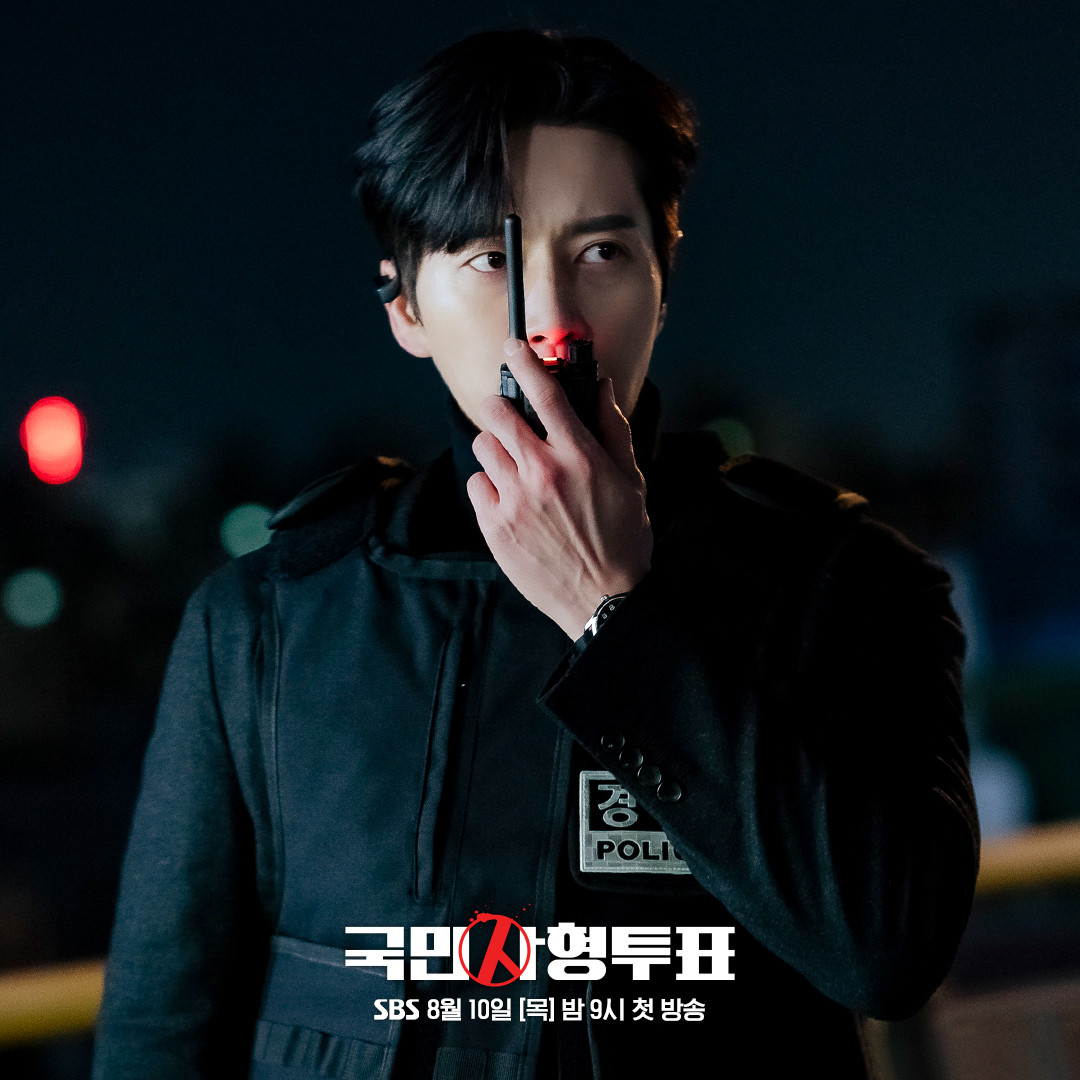Kim Moo Chan (Park Hae Jin) mặc áo chống đạn đang giao tiếp với ai đó bằng bộ đàm. Đôi mắt sắc bén của anh ấy gợi ý về sự nghiêm trọng tại chỗ. Kim Moo Chan (Park Hae Jin) mặc áo chống đạn đang giao tiếp với ai đó bằng bộ đàm. Đôi mắt sắc bén của anh ấy gợi ý về sự nghiêm trọng tại chỗ.