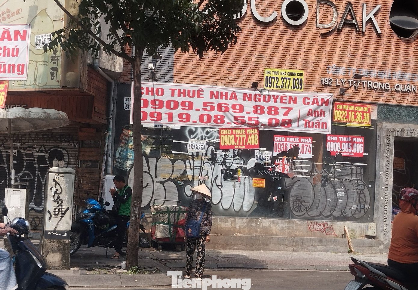 Anh N (35 tuổi, tài xế xe công nghệ) cho biết, cách đây vài năm, lô góc giao giữa đường Lý Tự Trọng và Trương Định được coi là vị trí gần như cố định của anh để đón khách vì lượng người ra vào các cửa hàng, quán ăn ở đây rất đông (ảnh trái). Năm nay, các mặt bằng đóng cửa và treo biển sang nhượng, cho thuê lại nên anh phải di chuyển vị trí đón khách đi xe. (Ảnh: Lộc Liên)