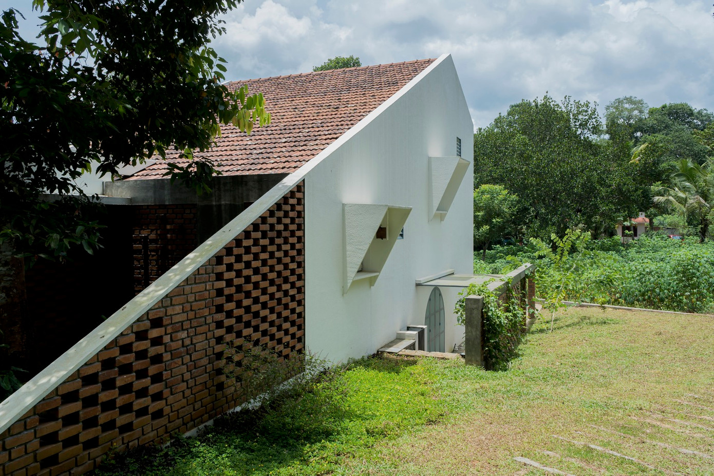 Ngôi nhà này được xây dựng trên một khu đất không bằng phẳng nên nhóm thiết kế đã lên ý tưởng xây dựng ngôi nhà cấp 4 gác lửng nép mình trong khu vườn xanh mát, với nhiều tầng cây.