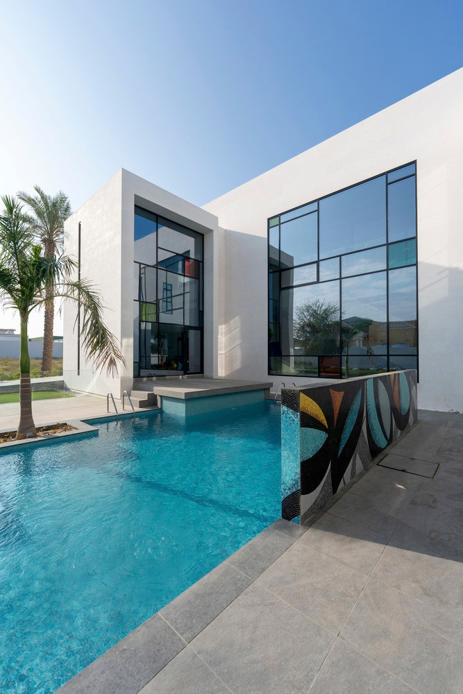 Không gian phòng khách rộng rãi có chiều cao gấp đôi nhìn ra sân hiên ngoài trời và hồ bơi đến khoảng sân rộng rãi gần với khu vực tiếp khách.