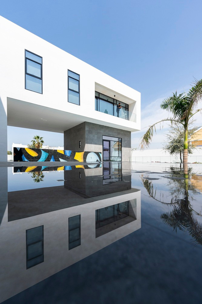 Không gian phòng khách rộng rãi có chiều cao gấp đôi nhìn ra sân hiên ngoài trời và hồ bơi đến khoảng sân rộng rãi gần với khu vực tiếp khách.