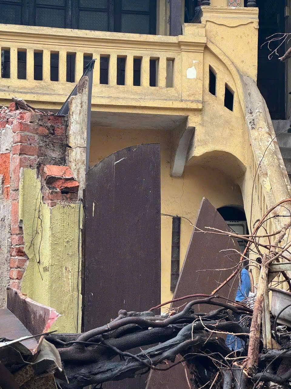 Cây đổ kéo sập nhà trên phố Chả Cá, phải cưa cây để cứu người ra.