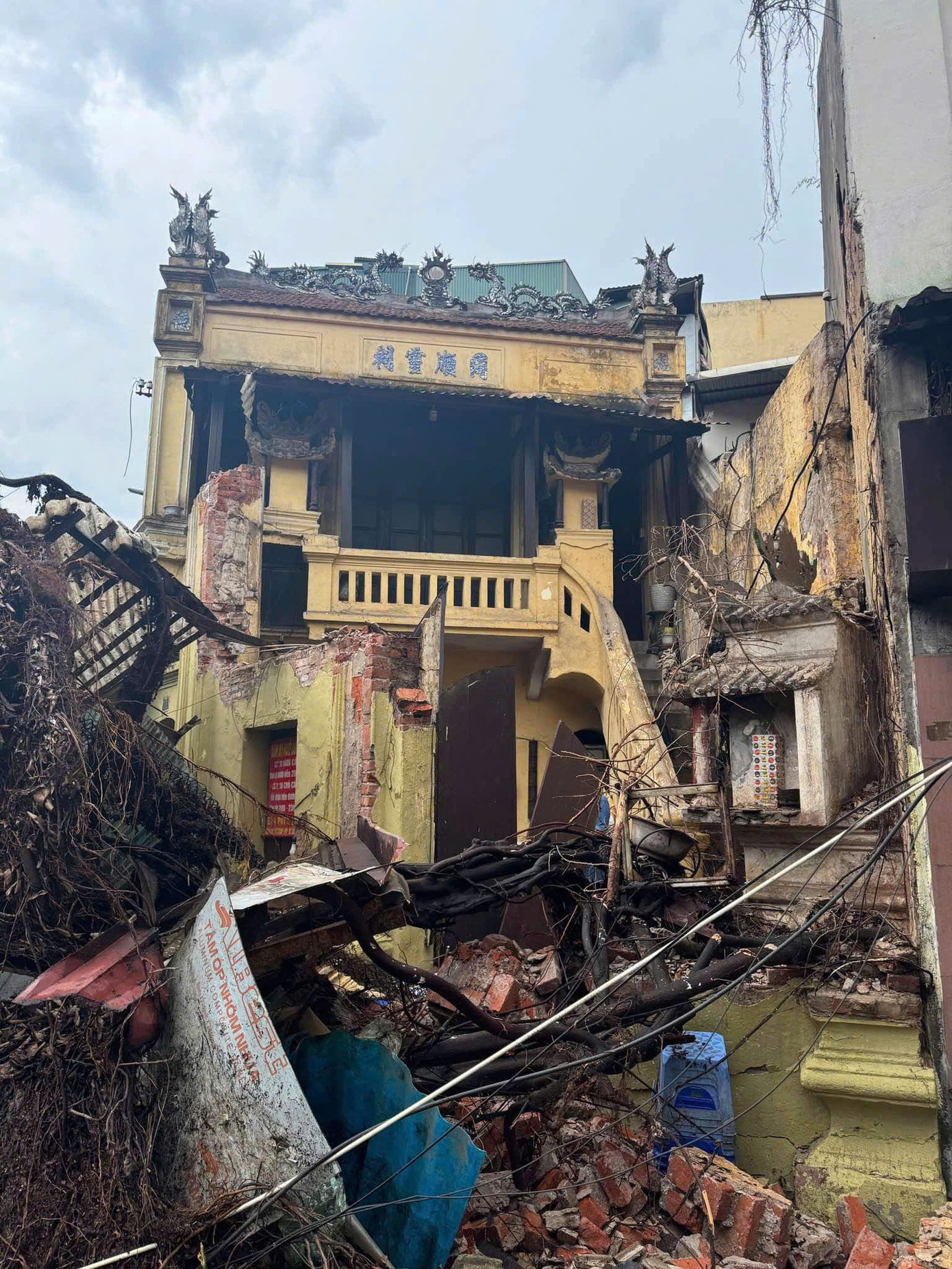 Cây đổ kéo sập nhà trên phố Chả Cá, phải cưa cây để cứu người ra.