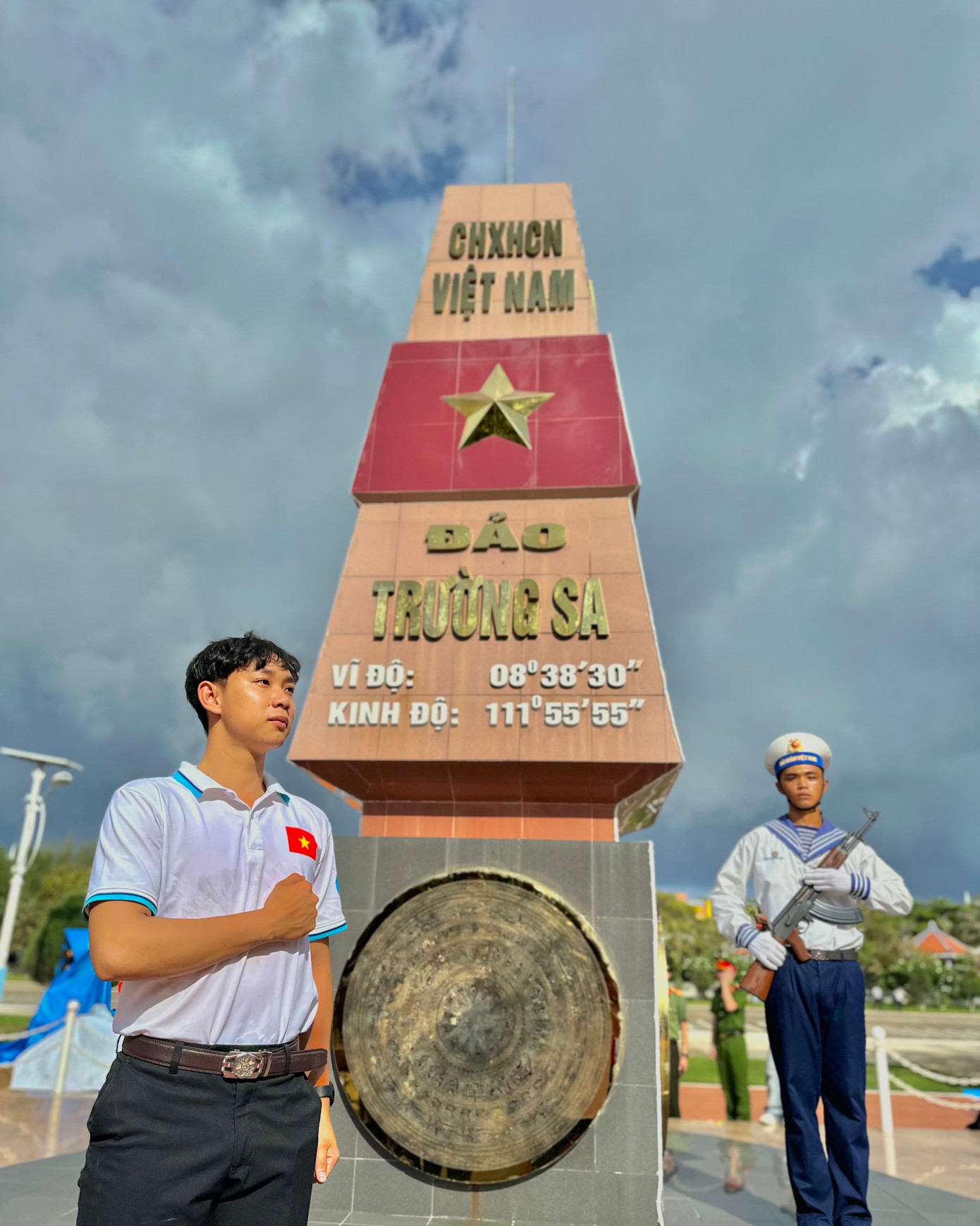 Hoàng Đa và chiến sỹ hải quân Việt Nam bên cột mốc chủ quyền trên đảo Trường Sa Lớn.