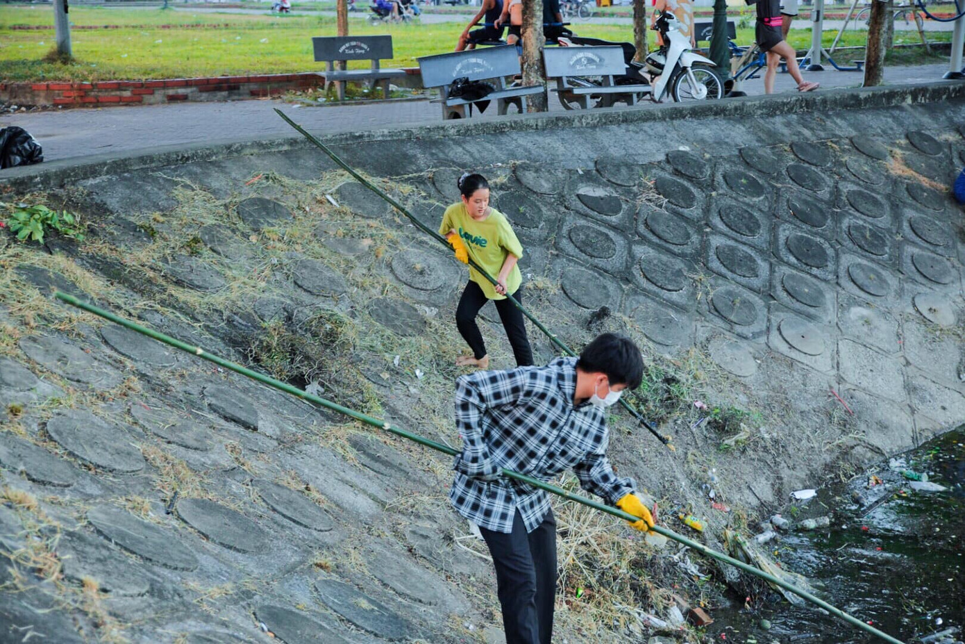 Cẩm Tú (áo vàng) đang hăng say thu gom rác thải.