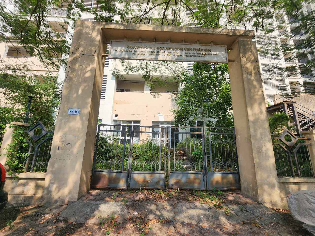 Cổng số 1 của Khu nhà ở cho học sinh sinh viên đã gỉ sét, đóng cửa nhiều năm. Bên trong cỏ mọc um tùm.