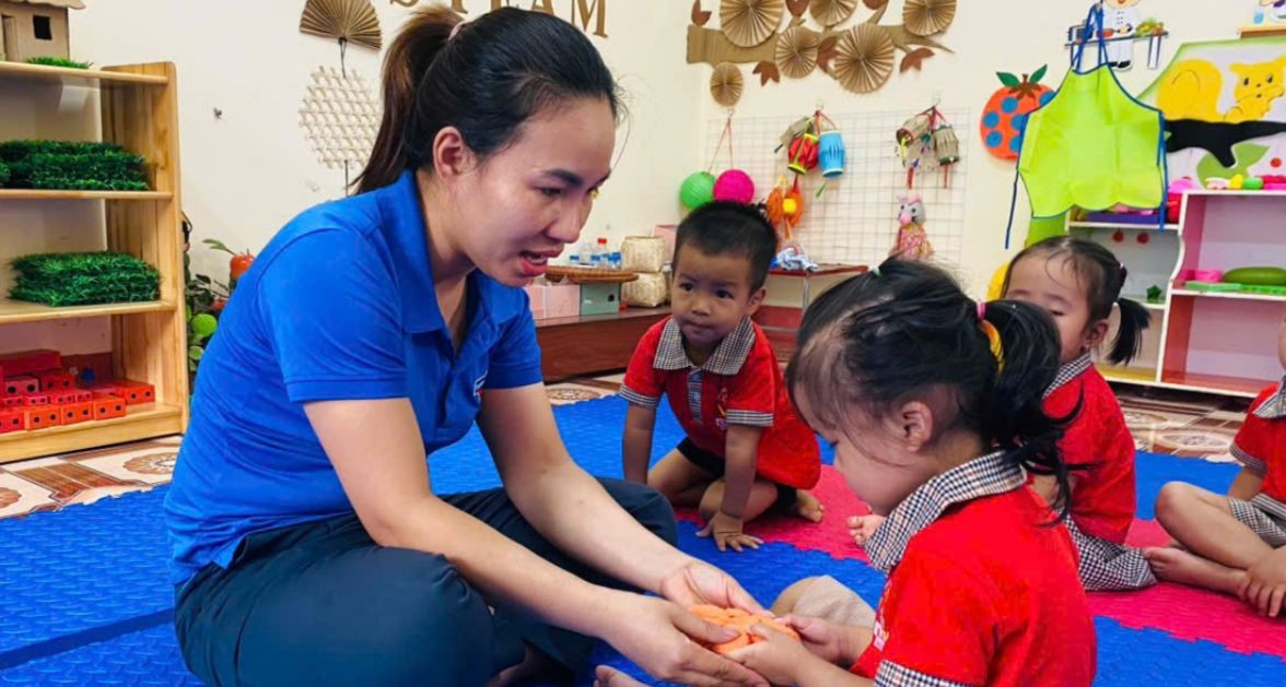 Cô giáo trẻ hướng dẫn các em nhỏ trong giờ học.
