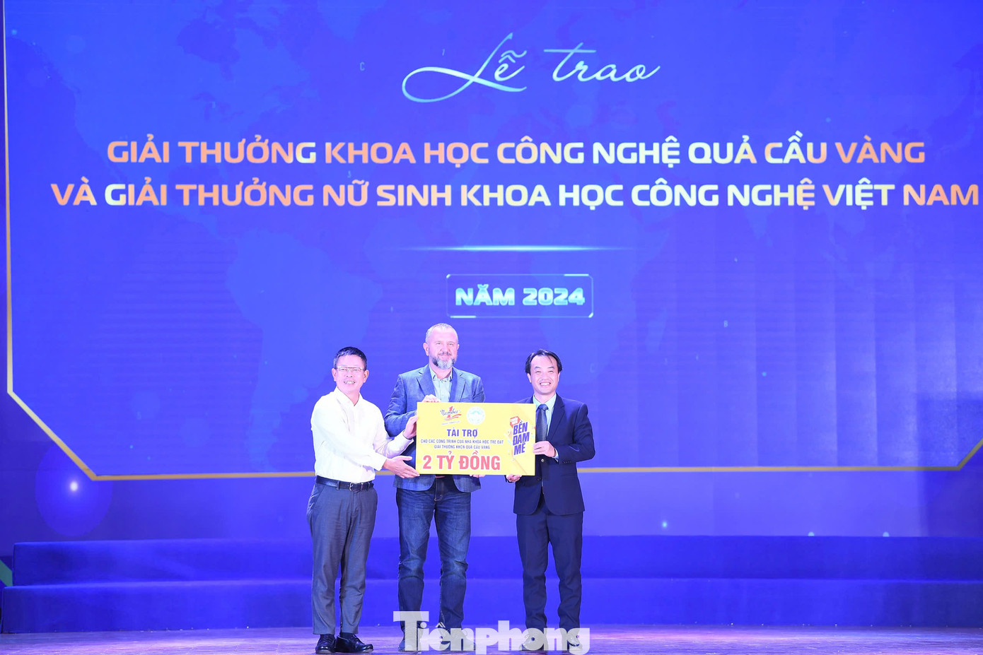 Nhà báo Phùng Công Sưởng - Tổng Biên tập Báo Tiền Phong, đại diện Quỹ hỗ trợ Tài năng trẻ Việt Nam và đại diện nhãn hàng Nước tăng lực Number 1 trao tài trợ 2 tỷ đồng cho các công trình khoa học của các tài năng trẻ đạt Giải thưởng Khoa học công nghệ Quả Cầu Vàng.