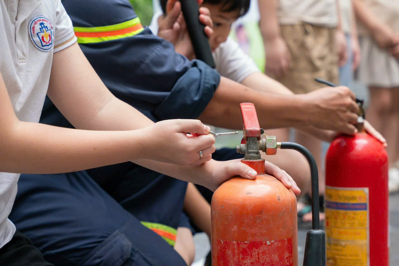 Cán bộ, chiến sĩ, đoàn viên thanh niên CATĐ tập huấn cho các em học sinh về kỹ năng sử dụng thiết bị chữa cháy, thoát hiểm.