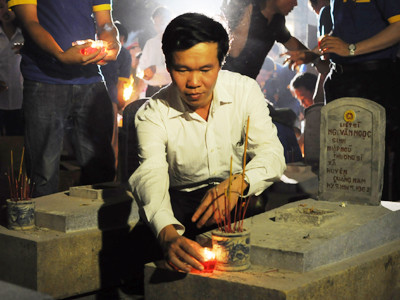 Anh Võ Văn Thưởng thắp nến tri ân tại nghĩa trang Trường Sơn Ảnh: Quang Minh