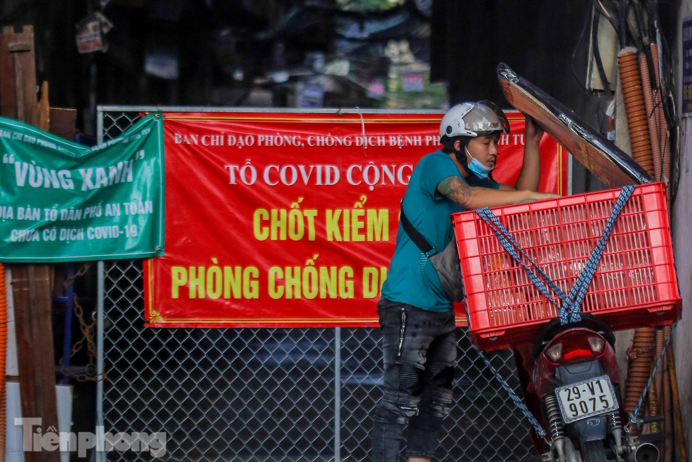 Rào chắn kiên cố tại một ngõ trên phố Kim Ngưu (quận Hai Bà Trưng, Hà Nội), shipper giao hàng qua rào.