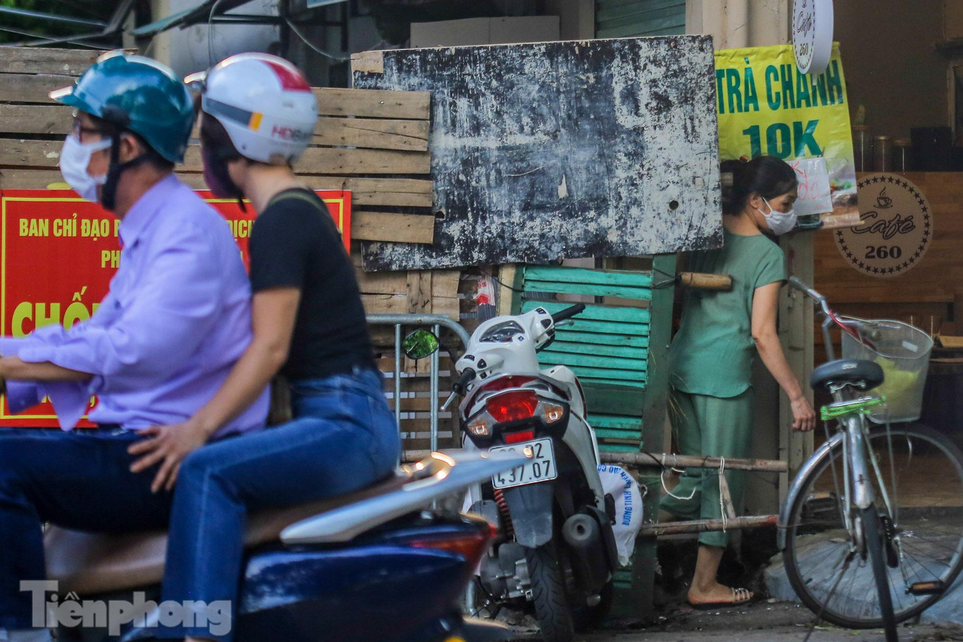 Người dân luồn lách qua rào chắn cứng để di chuyển.