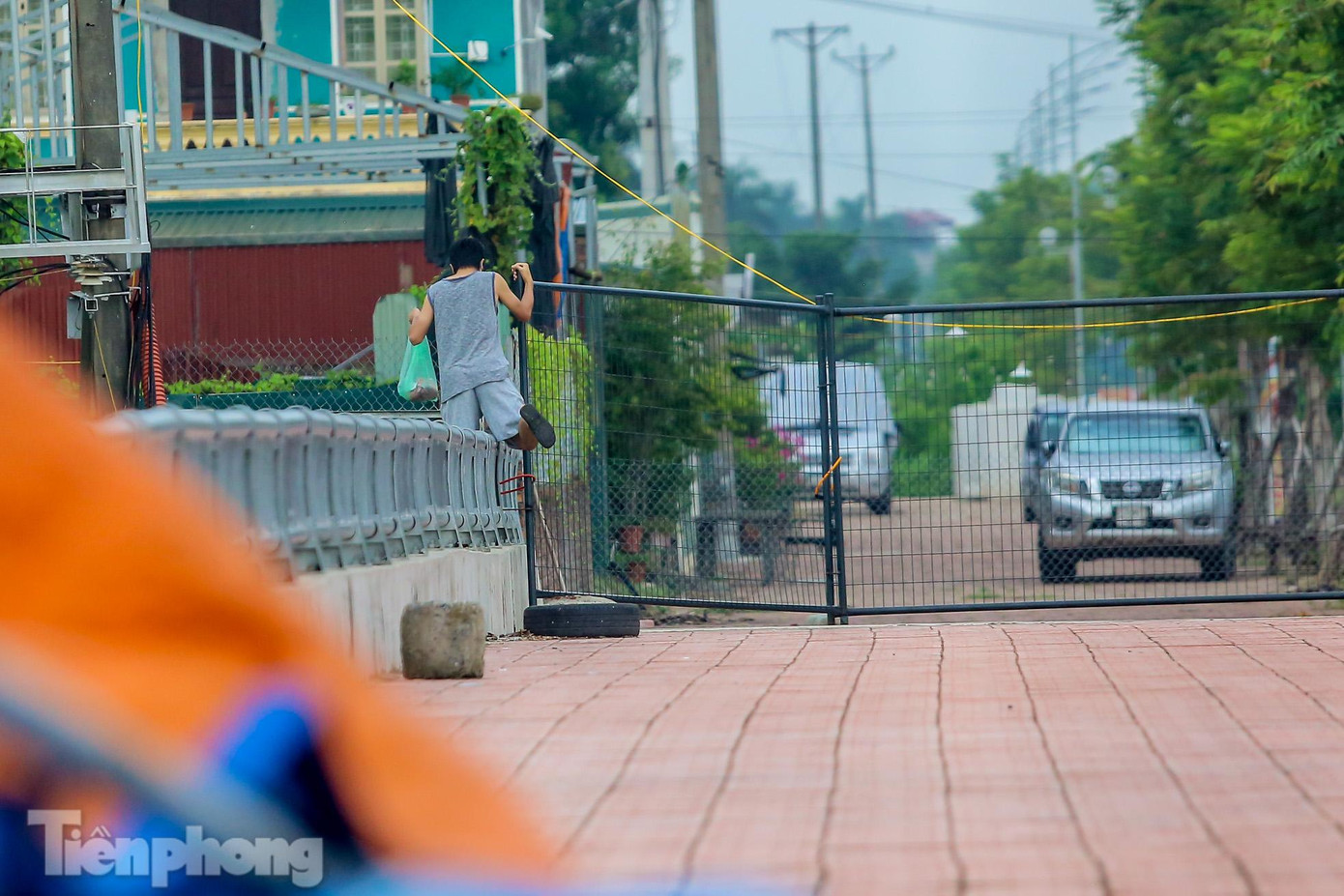 Ngoài cách chui dưới rào, một số người trèo qua thành cầu.