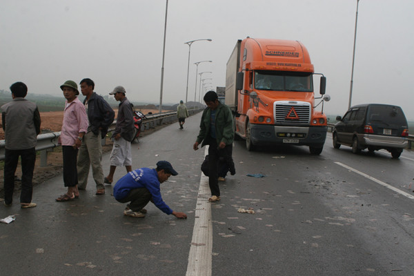 Một số người bất chấp nguy hiểm lao vào đầu xe đang chạy để nhặt tiền lẻ