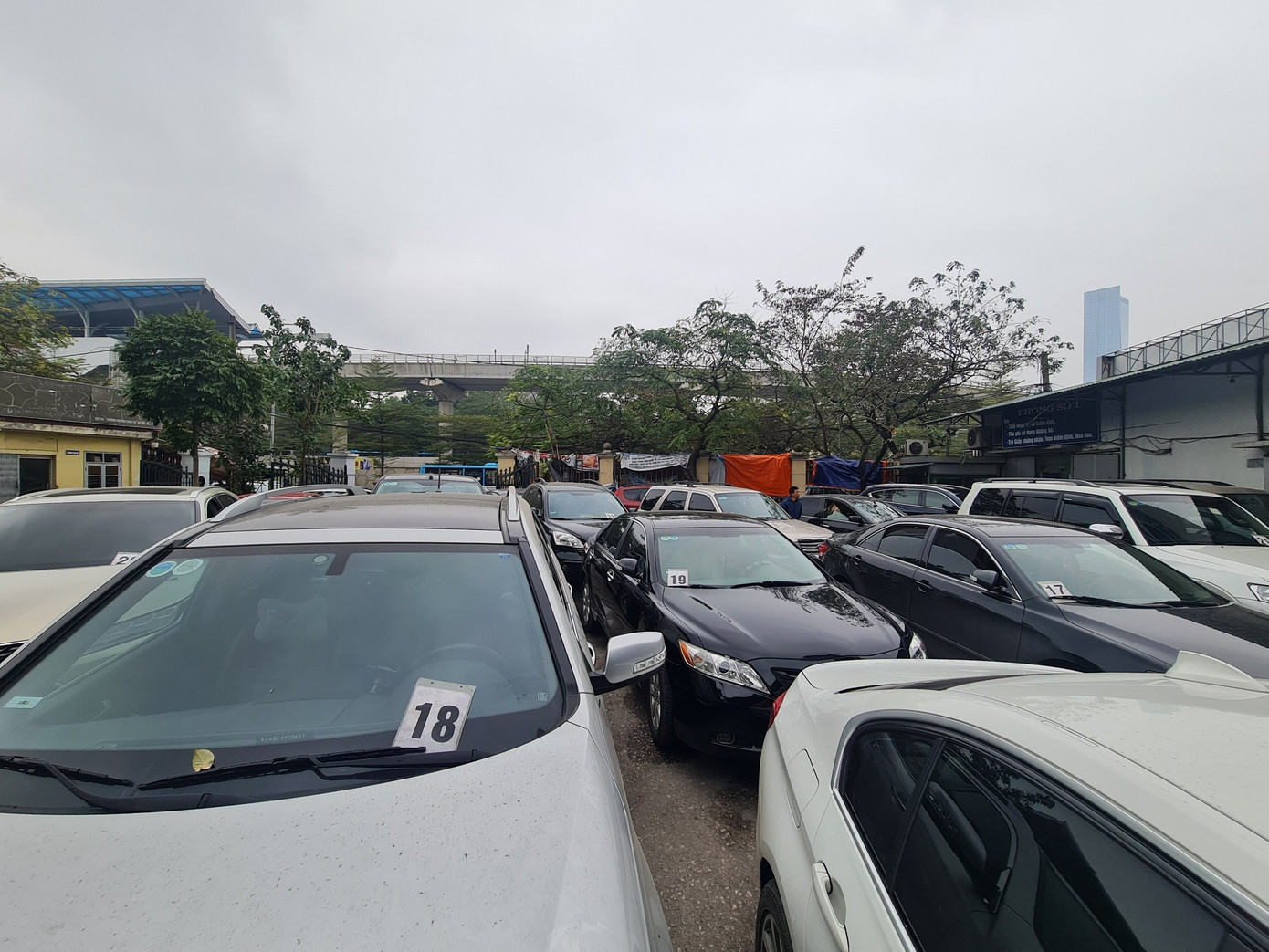 Sau khi đi qua cổng trung tâm, mỗi xe sẽ được phát một số thứ tự. Kiểm định viên ở đây khuyến cáo tài xế để số vào trong xe tránh trường hợp bị đổi số, mất số